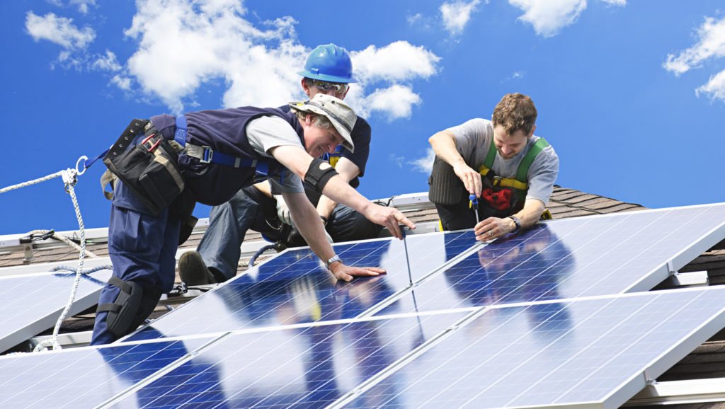 Specialisti installano pannelli solari su copertura